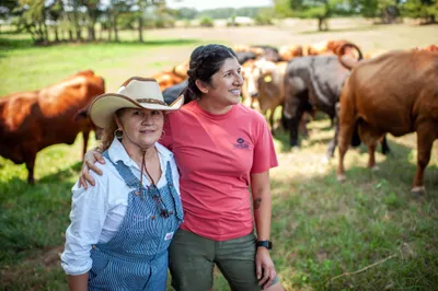 Maria Contreras, left, and her daughter, Lorena Jenkins, stand for a portrait after feeding cattle at their family farm in Blevins, Ark. on Sept. 7, 2023. Photo by Rory Doyle.
